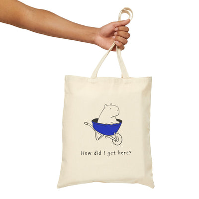 Capy Life natural canvas tote bag featuring a minimalist illustration of a capybara in a blue wheelbarrow.