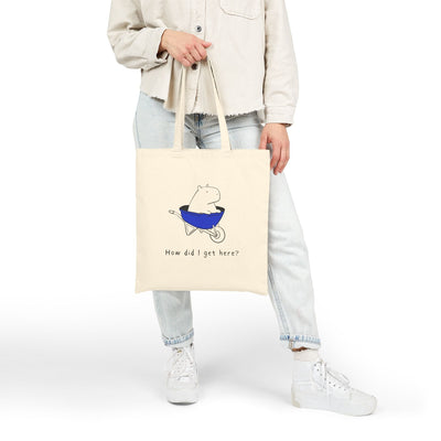 Capy Life natural canvas tote bag featuring a minimalist illustration of a capybara in a blue wheelbarrow.
