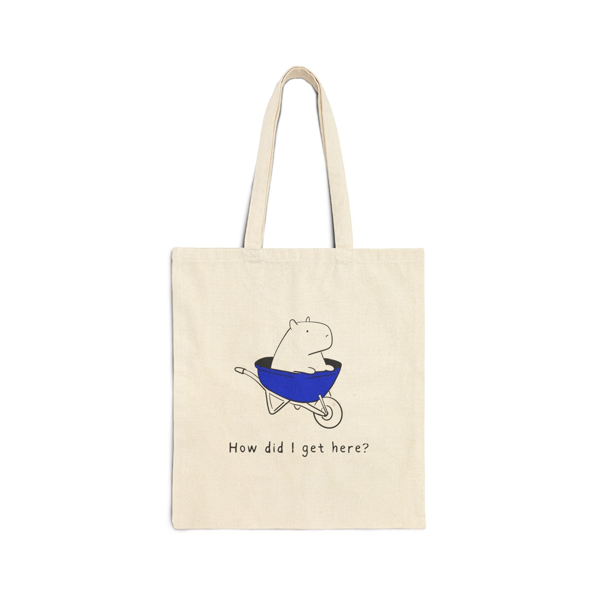 Capy Life natural canvas tote bag featuring a minimalist illustration of a capybara sitting in a bright blue wheelbarrow.