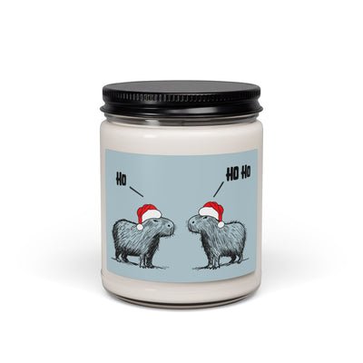 Capy Life Christmas white sage and lavender scented candle featuring two capybaras in Santa hats on a blue background with Ho Ho text