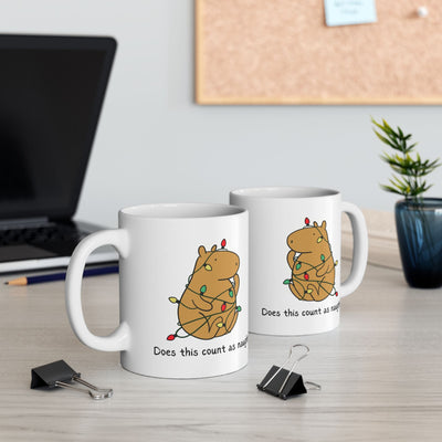 Two Capy Life white ceramic mugs featuring a capybara tangled in colorful Christmas lights with funny text