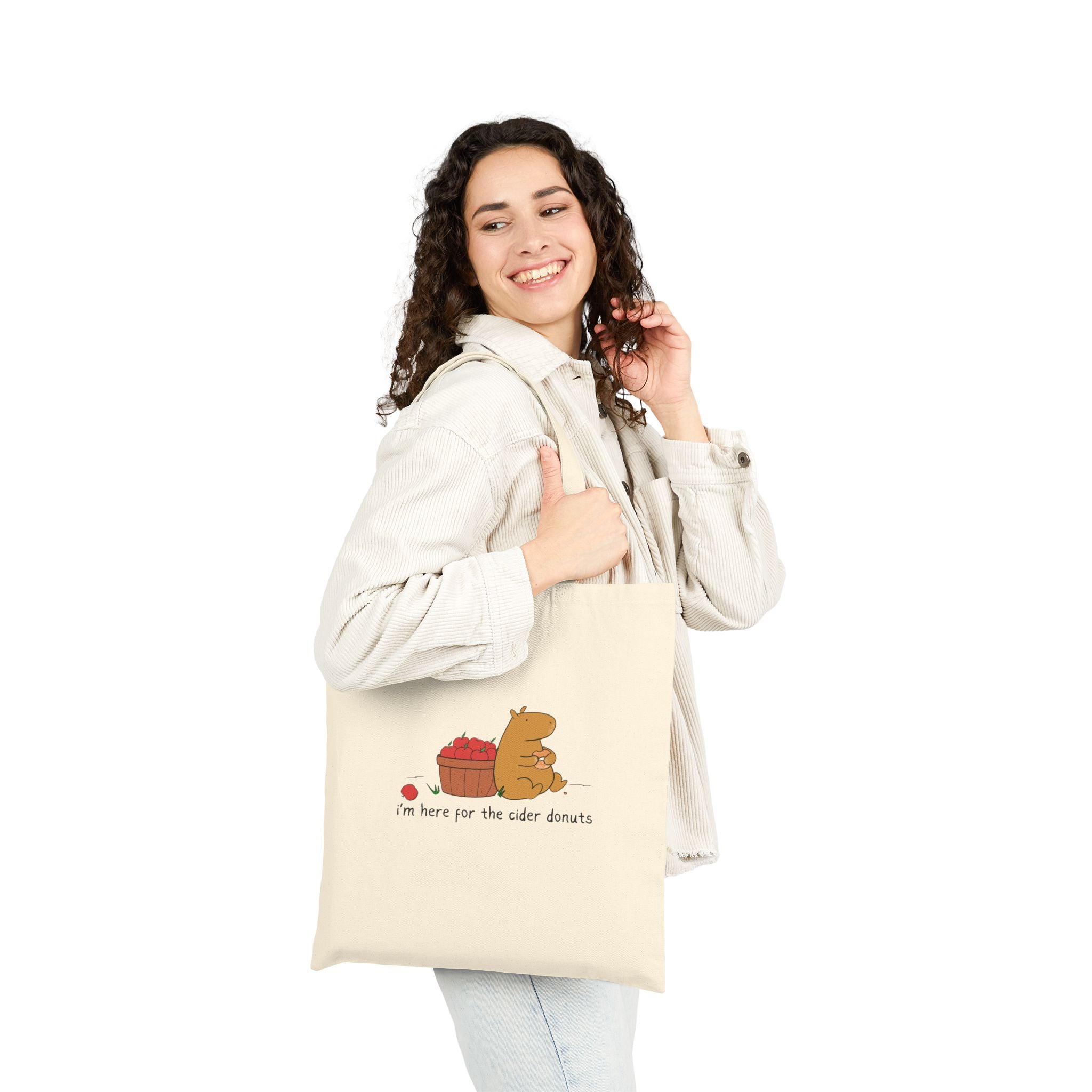 Capy Life natural canvas tote bag featuring a cute capybara with apples and the text I am here for the cider donuts