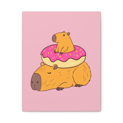Capy Life canvas wall art featuring a relaxed capybara with a smaller capybara sitting in a pink frosted donut.