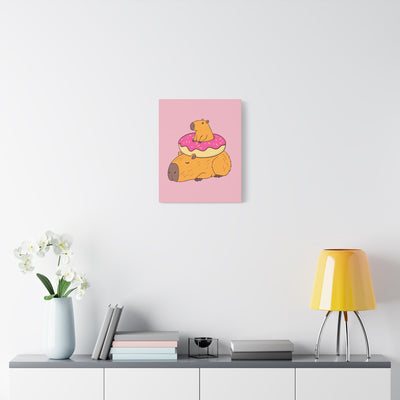 Capy Life canvas wall art featuring a relaxed capybara with a smaller one in a pink donut on a soft pink background.