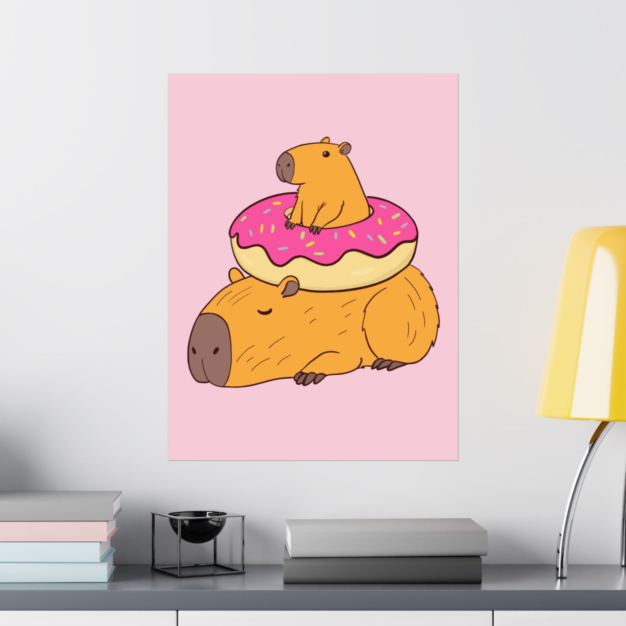Capy Life wall art print featuring a cute capybara sitting on a frosted donut atop another sleeping capybara.
