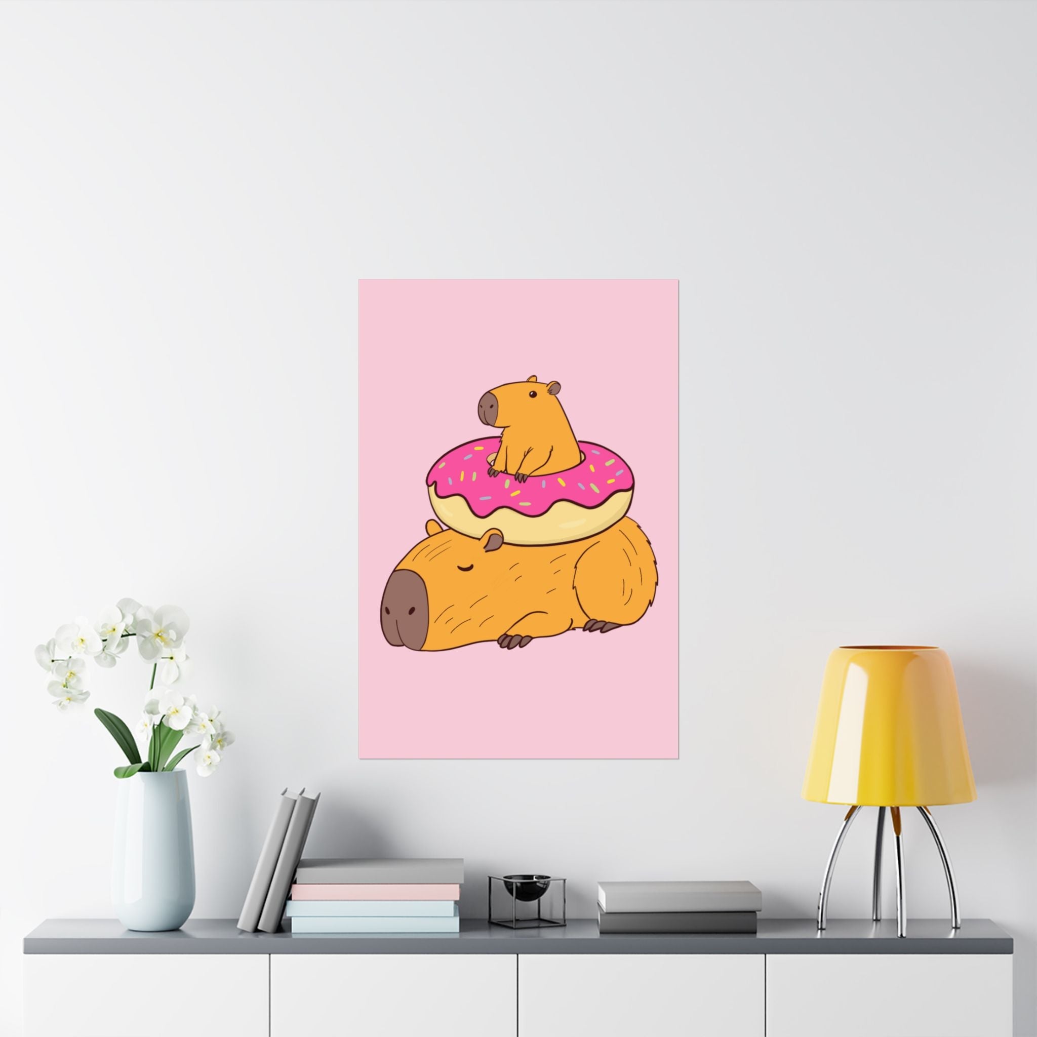 Capy Life wall art print featuring a cute capybara with a donut on its back, set against a soft pink background.