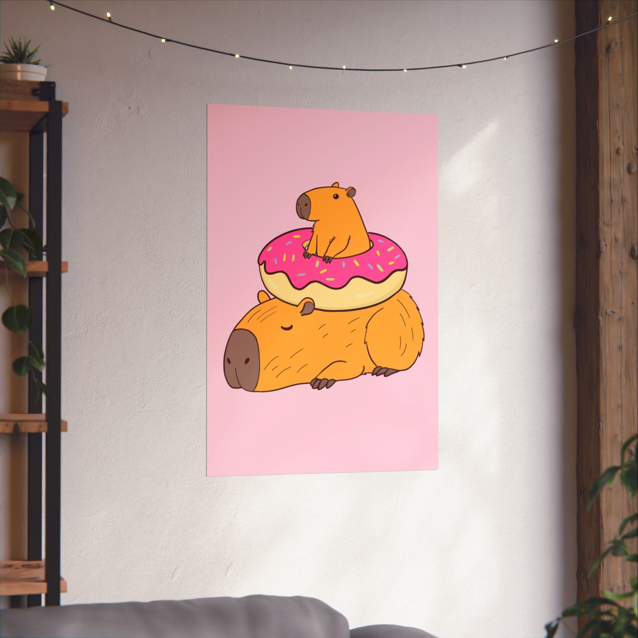 Capy Life wall art print featuring a cute capybara lounging under a pink frosted donut on a soft pink background.