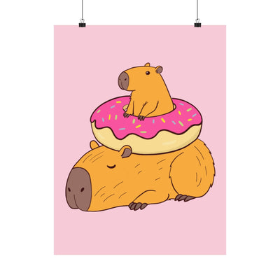 Capy Life wall art print featuring a cute capybara lounging under a frosted donut on a soft pink background.