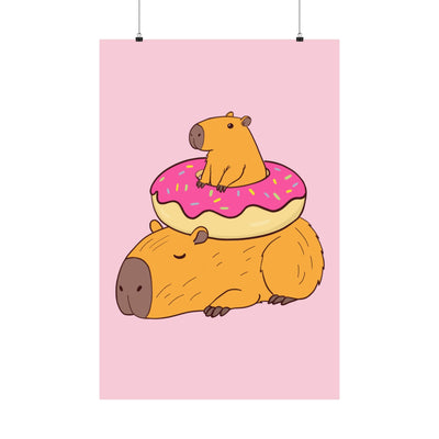 Capy Life wall art print featuring a cute capybara lounging under a pink frosted donut on a soft pink background.