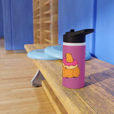 Capy Life 12oz stainless steel water bottle with a cute capybara sitting on a pink donut, set on a gym bench.