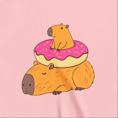 Capy Life youth tee featuring a cute graphic of two capybaras, one sitting inside a pink frosted donut on a pink shirt