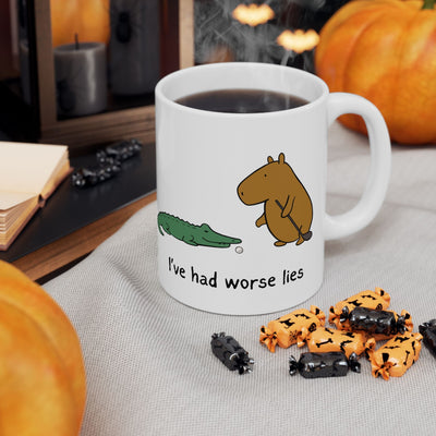 Capy Life ceramic coffee mug featuring a capybara and alligator golf scene with the text I've had worse lies