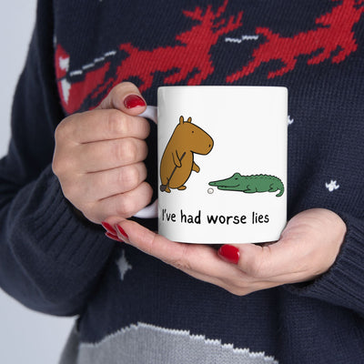 Capy Life white ceramic coffee mug featuring a capybara and alligator golf illustration with I have had worse lies text
