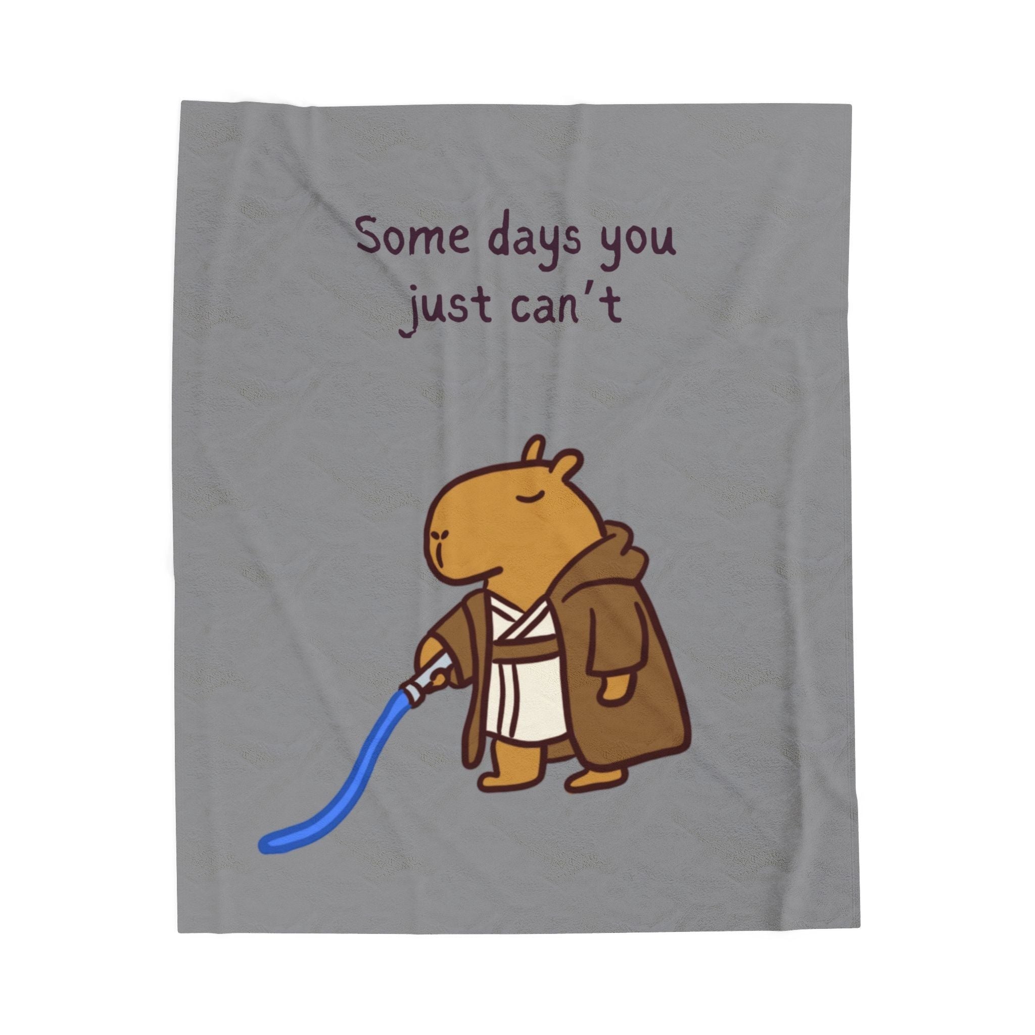 Capy Life velveteen plush blanket featuring a tired capybara Jedi with a blue lightsaber and the text Some days you just can’t.