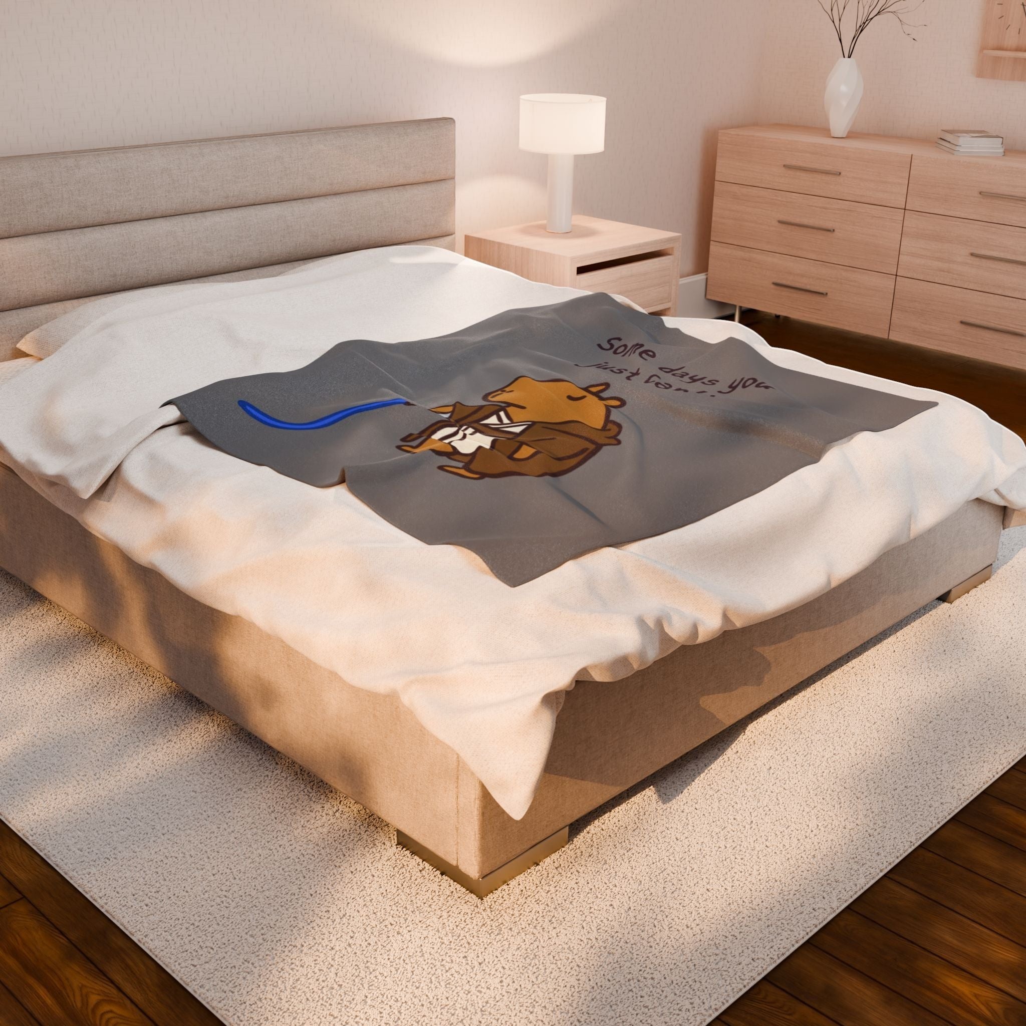 Capy Life velveteen plush blanket featuring a capybara Jedi illustration on a grey background, draped on a bed.