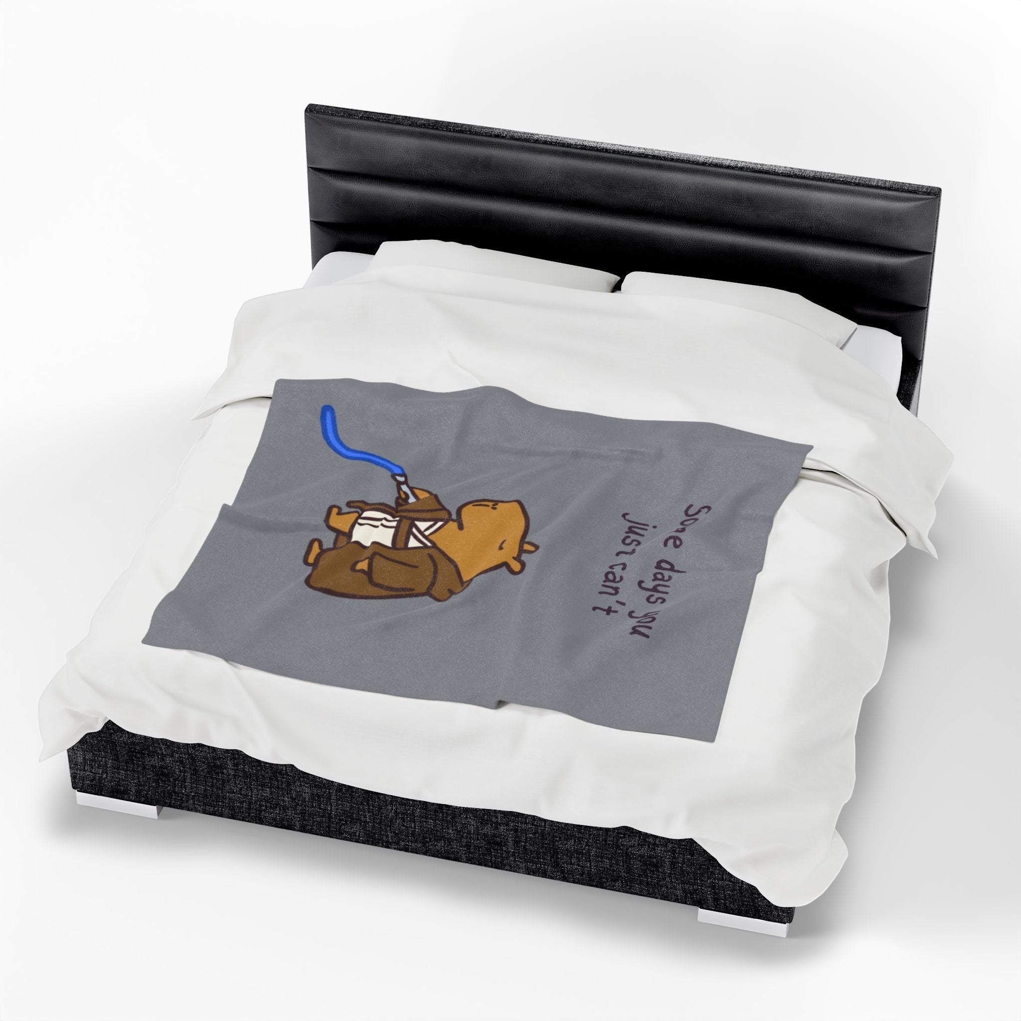 Capy Life velveteen plush blanket featuring a tired capybara Jedi illustration on a grey background, draped on a bed.
