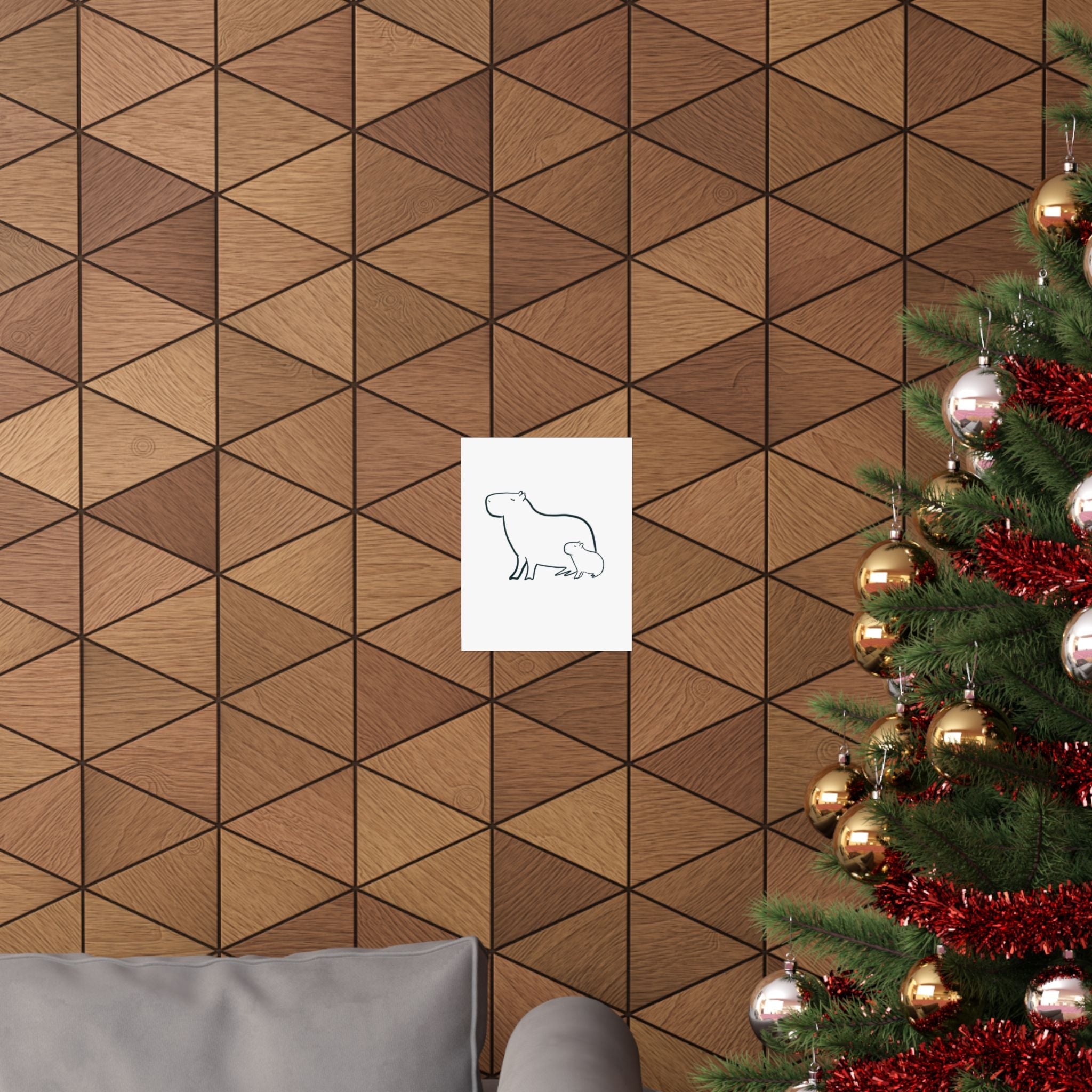 Capy Life minimalist line drawing of a mama and baby capybara hanging on a geometric wood wall near a Christmas tree.