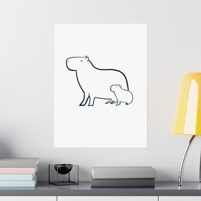 Capy Life minimalist line art print of a mama and baby capybara on a white wall above a desk with a yellow lamp.
