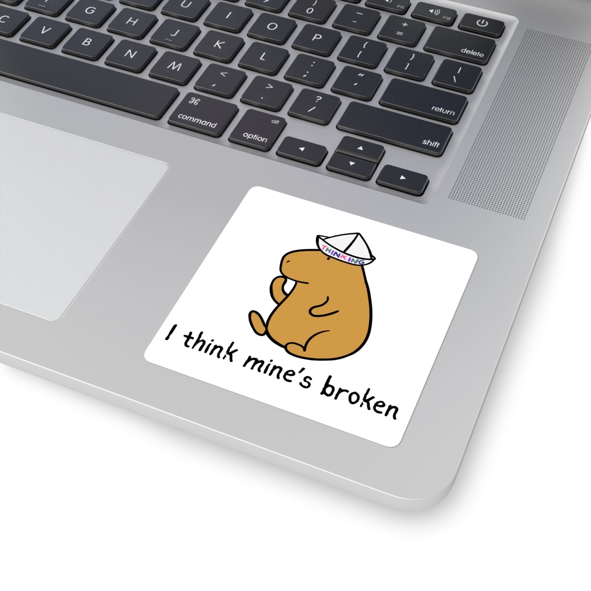 Capy Life sticker featuring a cute capybara wearing a paper thinking hat on a laptop with the text I think mine’s broken