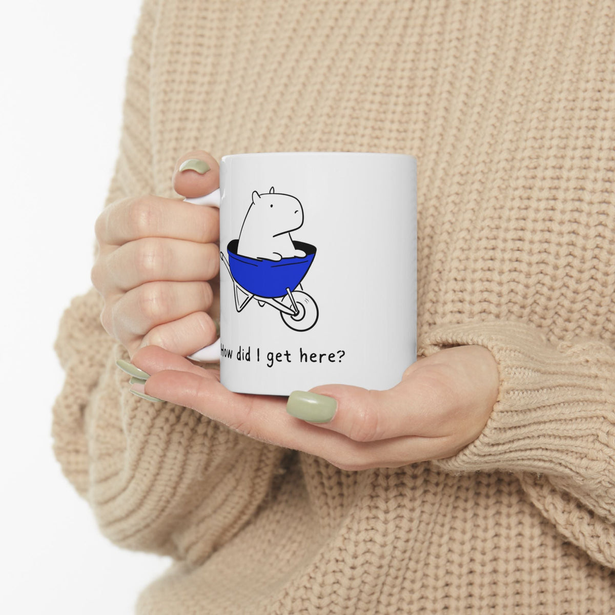 Capy Life white ceramic coffee mug featuring a cute capybara in a blue wheelbarrow with the text How did I get here