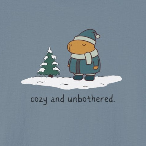 Capy Life softstyle t-shirt featuring a capybara in winter gear standing in snow with the text cozy and unbothered.