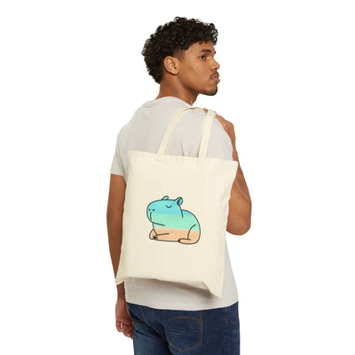 Capy Life coastal capybara canvas tote bag in natural cotton worn over the shoulder by a man in a white t-shirt.