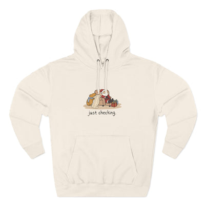 Capy Life cream fleece hoodie featuring a hand-drawn capybara checking Santa's naughty-or-nice list.