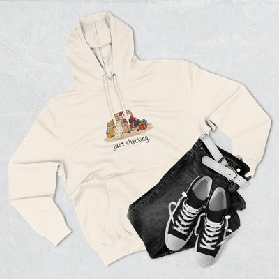 Capy Life cream fleece hoodie featuring a funny capybara illustration and the text just checking, styled with jeans.