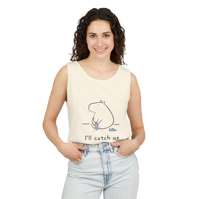 Woman wearing a Capy Life cream Comfort Colors tank top with a minimalist capybara illustration and text.