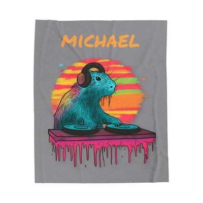 Capy Life DJ Capybara fleece blanket featuring a colorful capybara DJ with headphones on a grey velveteen background.