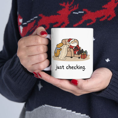Capy Life white ceramic mug featuring a capybara in a blue scarf checking Santa's naughty or nice list.