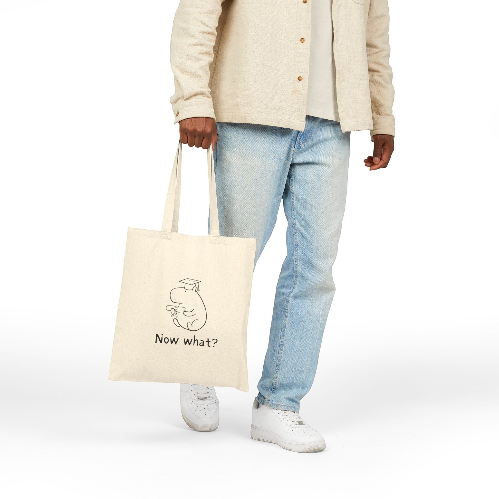 Capy Life natural cotton canvas tote bag with a minimalist capybara wearing a graduation cap and the text Now what