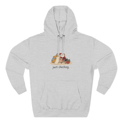 Capy Life grey fleece hoodie featuring a funny illustration of a capybara checking Santa's naughty-or-nice list.