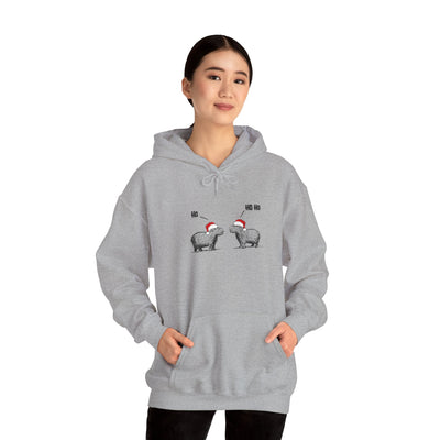 A woman wearing a grey Capy Life hoodie featuring a sketch of two capybaras in Santa hats saying Ho Ho Ho.