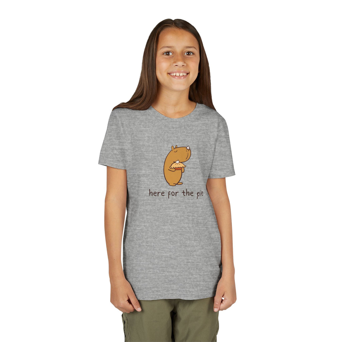 A girl wearing a Capy Life grey t-shirt featuring a cute capybara holding a pie with the text here for the pie