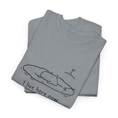 Capy Life grey t-shirt featuring a minimalist doodle of a capybara relaxing in a golf sand bunker with the text I live here now.