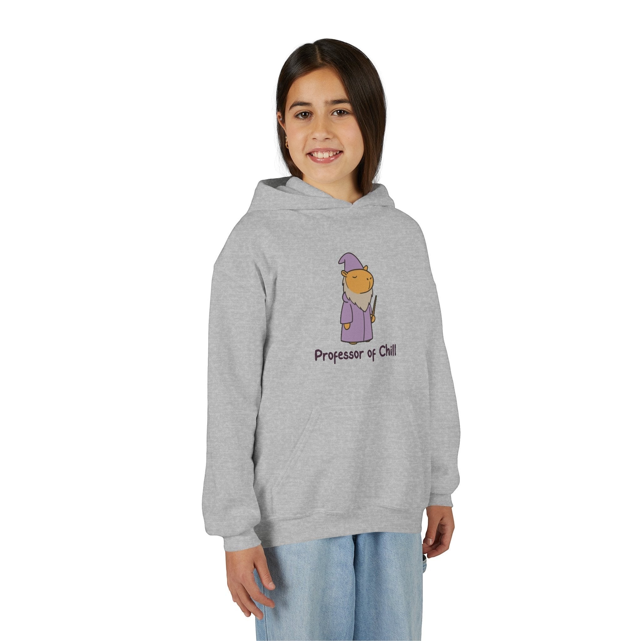 A smiling girl wearing a grey Capy Life kids hoodie featuring a wizard capybara graphic and Professor of Chill text.