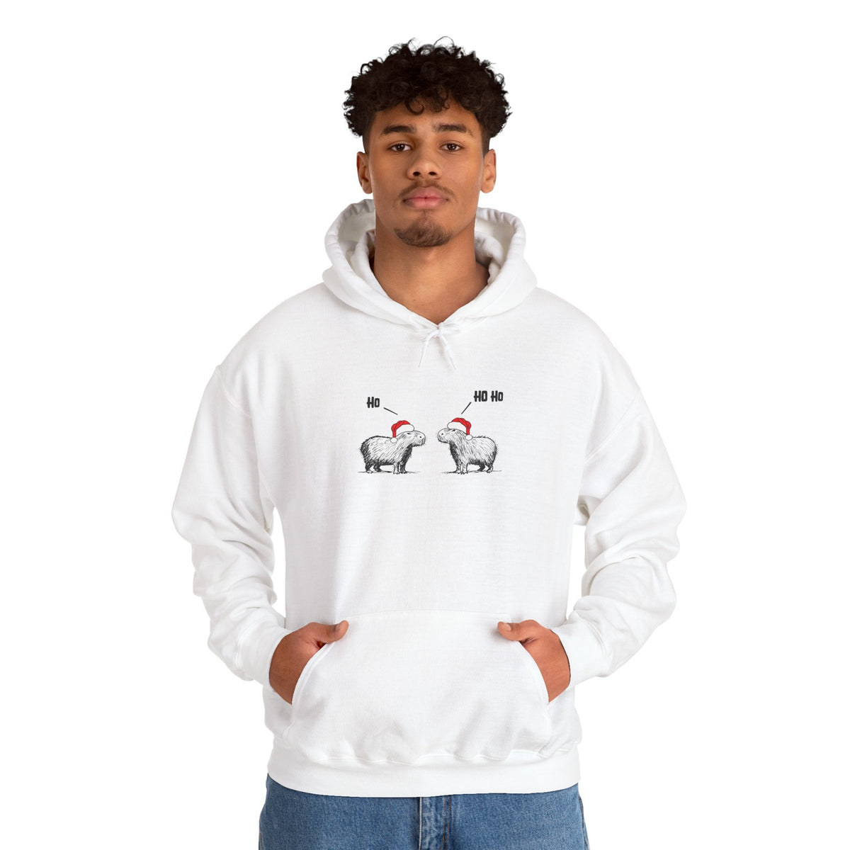 A man wearing a white Capy Life hoodie featuring a sketch of two capybaras in Santa hats saying Ho Ho Ho.