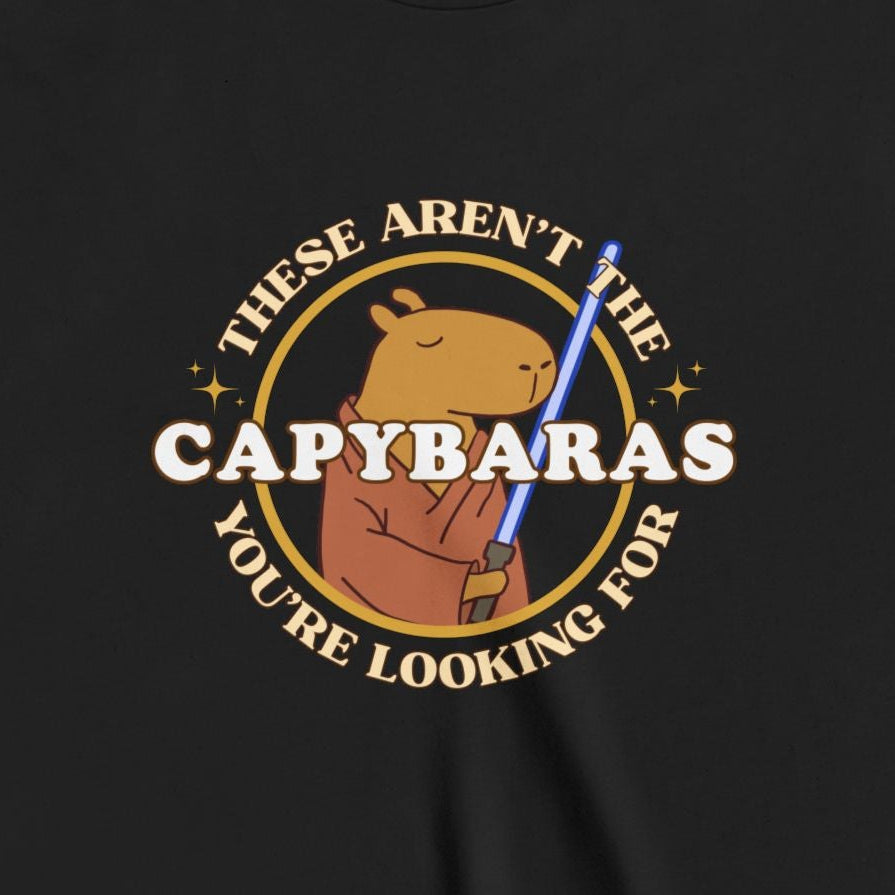 Capy Life youth tee featuring a comic-style badge graphic of a Jedi capybara holding a blue lightsaber on black cotton