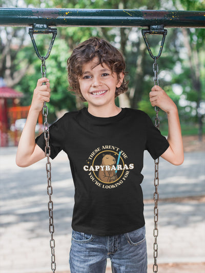 Capy Life youth wearing a black cotton t-shirt with a Jedi capybara comic badge graphic on a playground swing