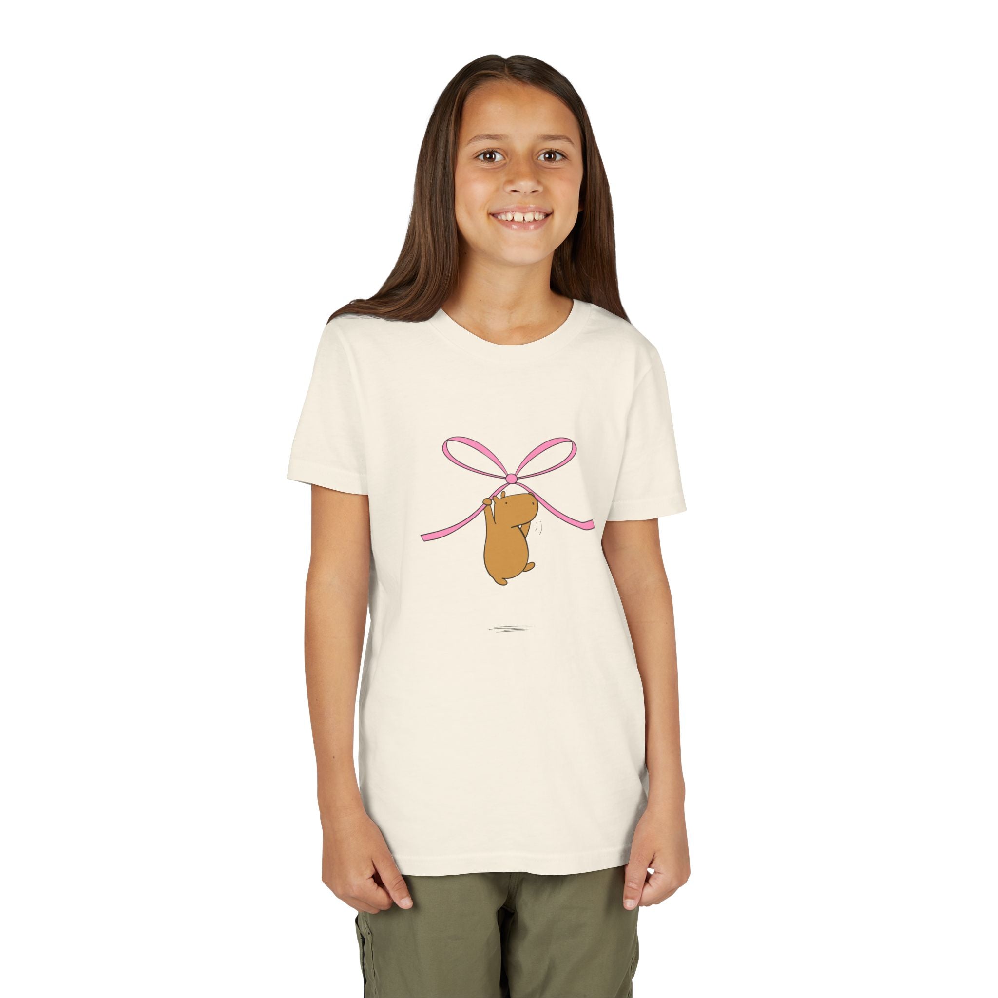 Capy Life kids cream t-shirt featuring a cute capybara hanging from a pink coquette bow graphic
