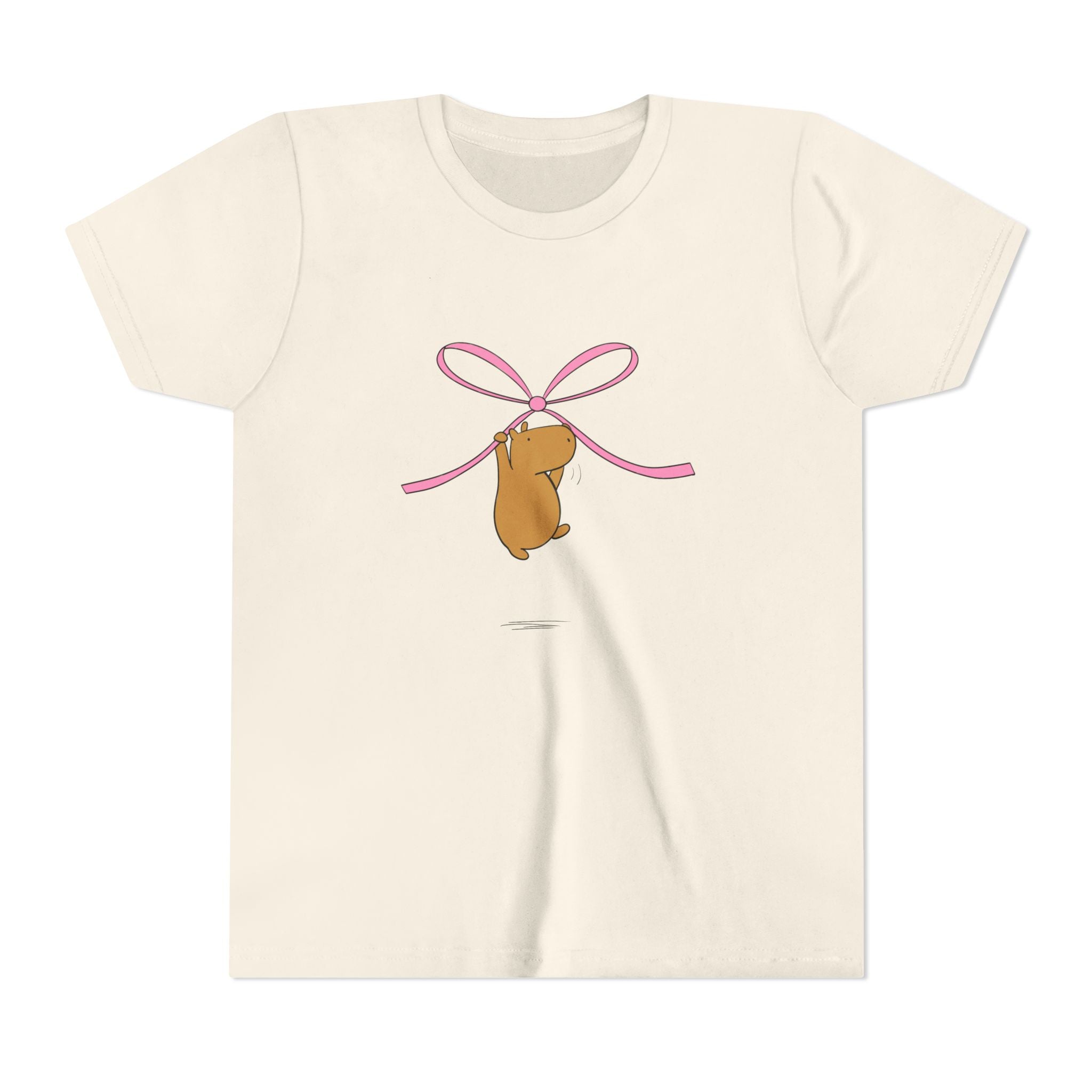 Capy Life kids cream t-shirt featuring a cute capybara graphic hanging from a pink coquette ribbon bow
