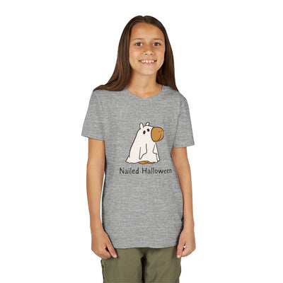 A young girl wearing a grey Capy Life kids t-shirt featuring a cartoon capybara in a ghost costume with Nailed Halloween