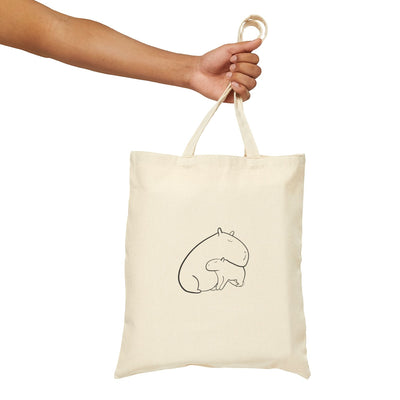 Capy Life natural canvas tote bag featuring a minimalist line drawing of a mother capybara snuggling her baby.