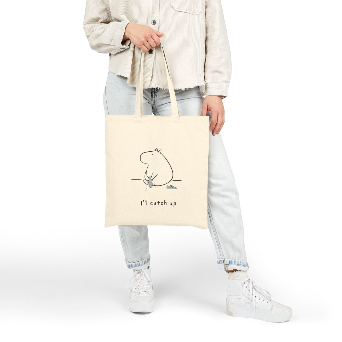 Capy Life natural cotton canvas tote bag featuring a minimalist capybara line drawing and the text I’ll catch up.