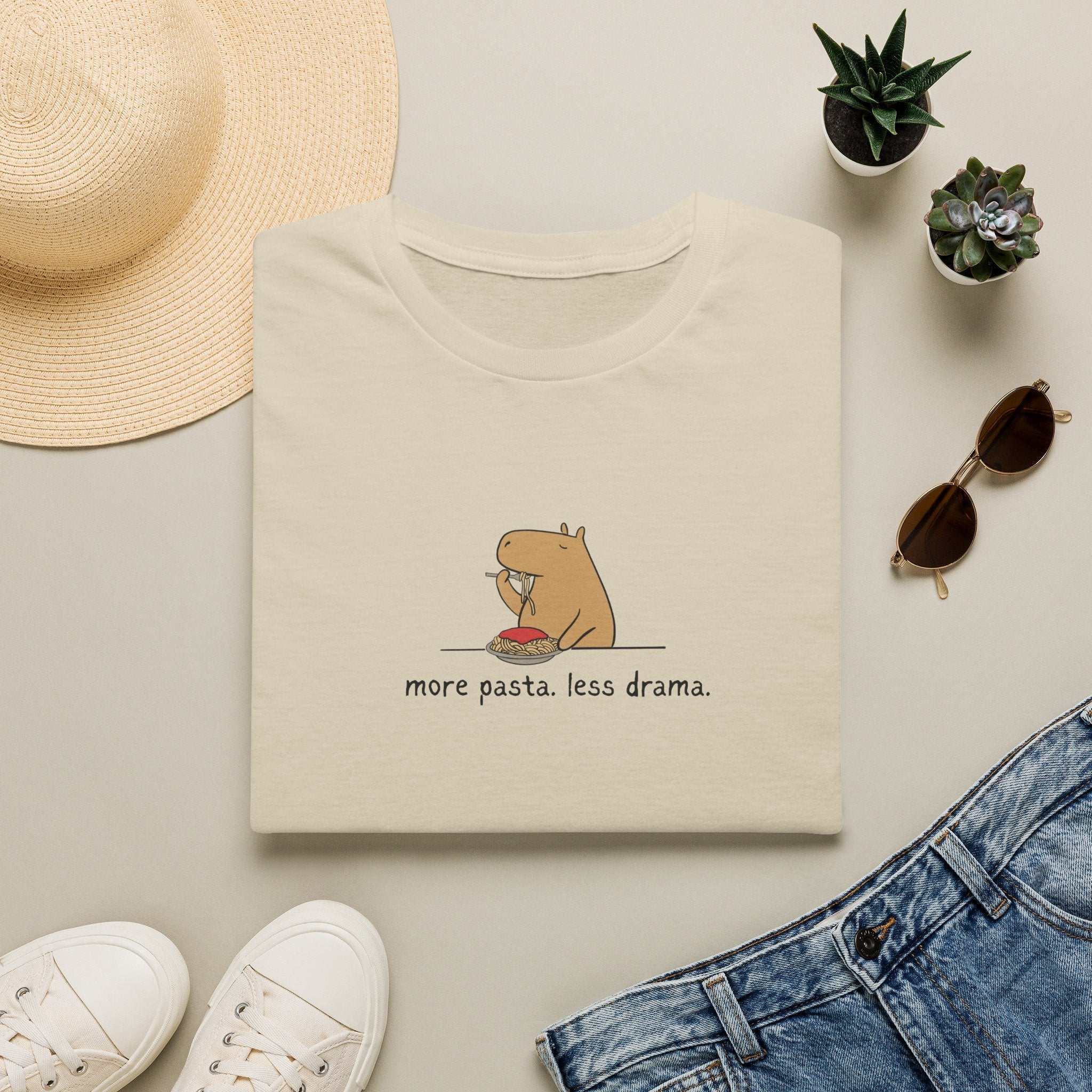Capy Life minimalist beige t-shirt featuring a cute capybara eating spaghetti with the text more pasta less drama
