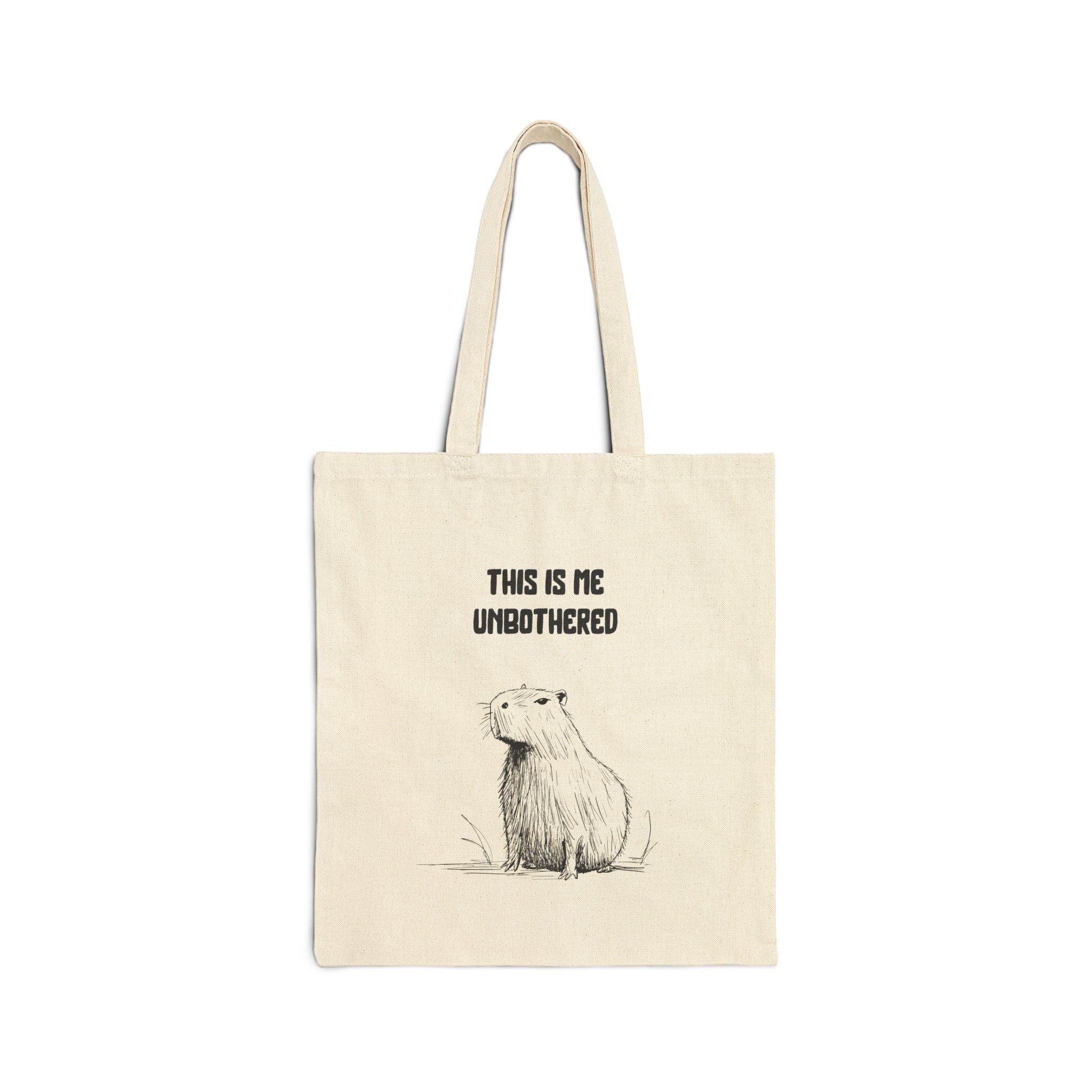 Capy Life natural canvas tote bag featuring a minimalist capybara illustration and the text This Is Me Unbothered
