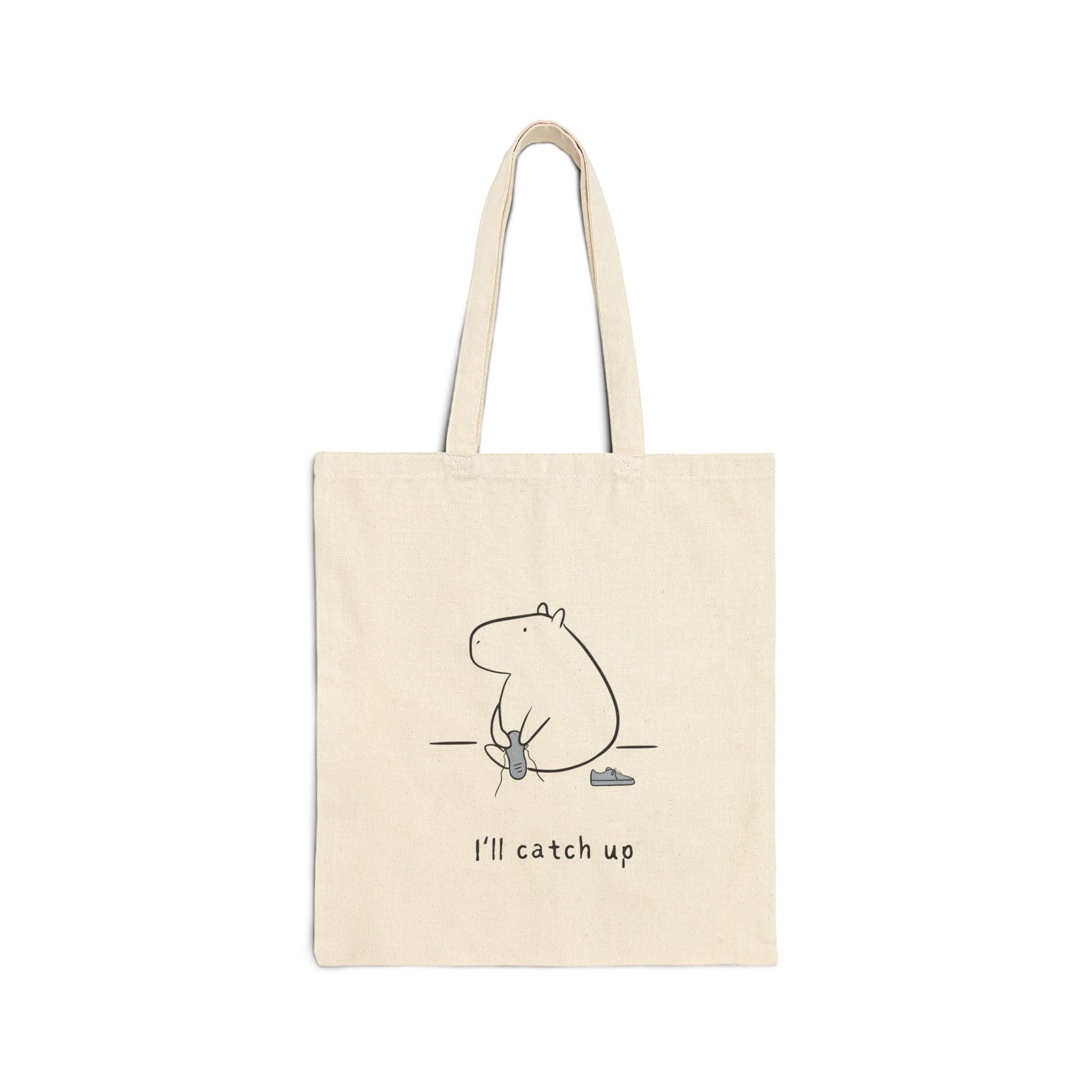 Capy Life natural cotton canvas tote bag featuring a minimalist capybara line drawing and the text I’ll catch up.