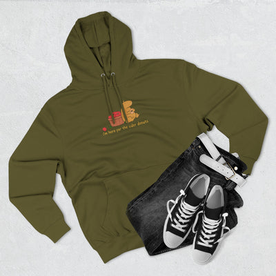 Capy Life olive green fleece hoodie with a cute capybara illustration and cider donut text, styled with black jeans.