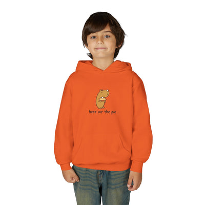 A young boy wearing a bright orange Capy Life kids hoodie featuring a cute capybara eating pie illustration.